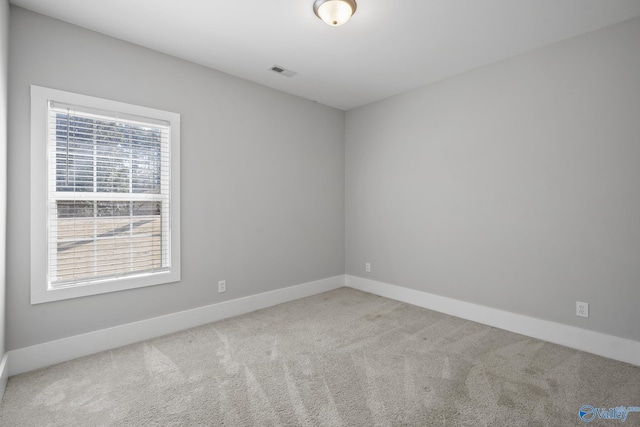 spare room featuring visible vents, baseboards, and carpet