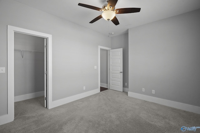 unfurnished bedroom with a closet, baseboards, a ceiling fan, and carpet flooring