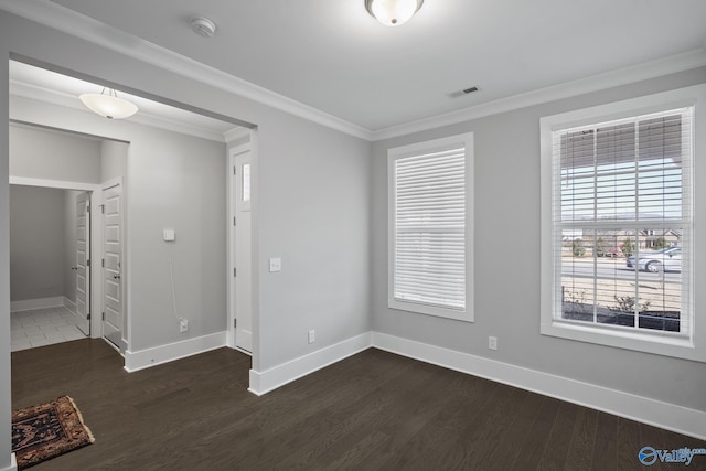 spare room with visible vents, crown molding, and dark wood-type flooring