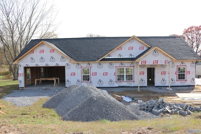 property in mid-construction with a shingled roof, driveway, and an attached garage