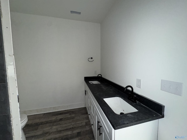 bathroom with baseboards, a sink, toilet, and wood finished floors