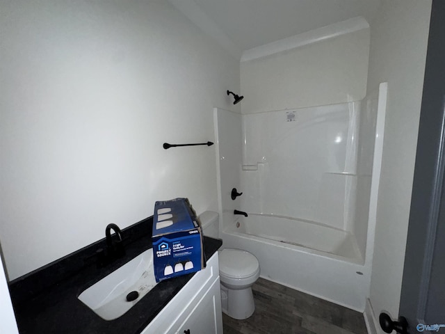 bathroom featuring toilet, a sink, wood finished floors, and shower / tub combination