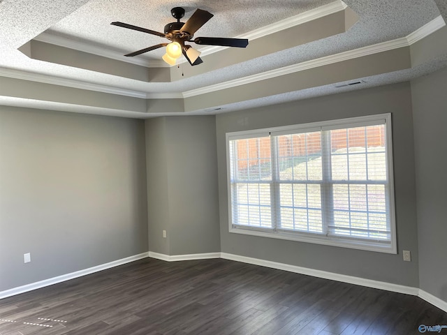 spare room with a raised ceiling, visible vents, and dark wood-style flooring