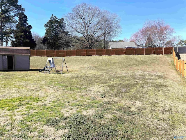 view of yard with an outbuilding, a shed, and a fenced backyard