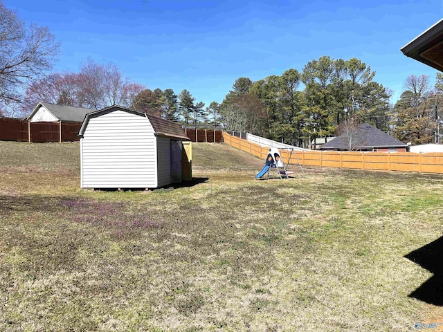 view of yard with an outbuilding, a shed, and a fenced backyard