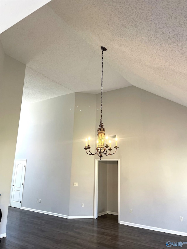 unfurnished room featuring dark wood-style flooring, a notable chandelier, a textured ceiling, high vaulted ceiling, and baseboards