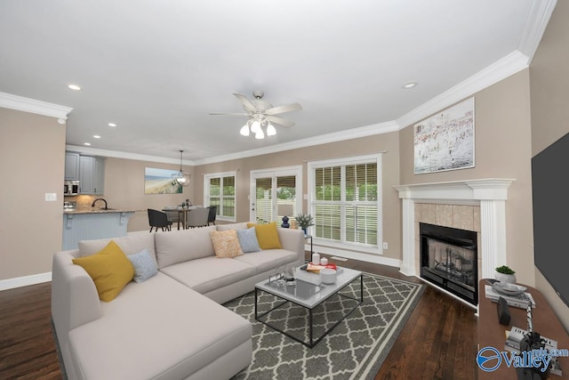 22656 Riviera Dr, Athens, AL 35613 - living area featuring ceiling fan, dark wood-style flooring, ornamental molding, baseboards, and a tiled fireplace