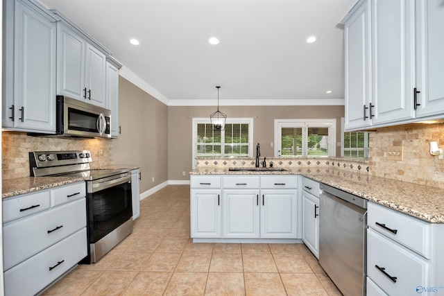 22656 Riviera Dr, Athens, AL 35613 - kitchen featuring stainless steel appliances, a sink, decorative backsplash, crown molding, and light tile patterned floors