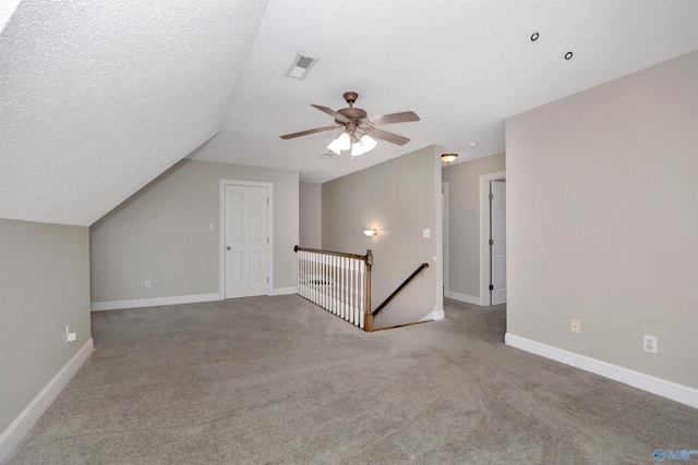 22656 Riviera Dr, Athens, AL 35613 - additional living space with carpet flooring, a ceiling fan, vaulted ceiling, baseboards, and a textured ceiling