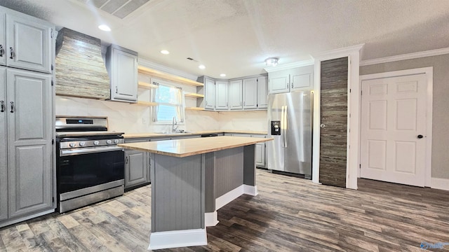 kitchen with dark hardwood / wood-style flooring, gray cabinetry, appliances with stainless steel finishes, and a center island