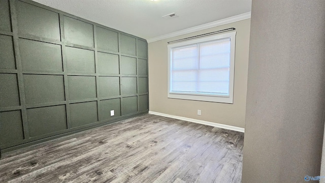 spare room featuring light hardwood / wood-style floors and ornamental molding