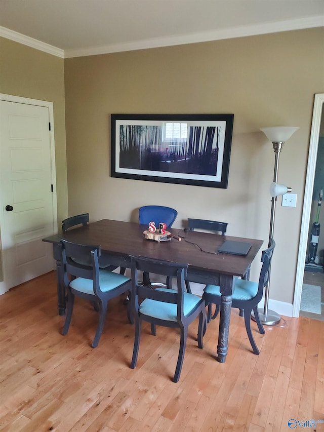 dining area with light hardwood / wood-style floors and crown molding