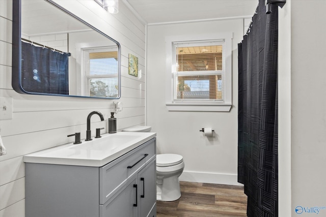 bathroom with toilet, wood walls, vanity, wood finished floors, and a shower with curtain