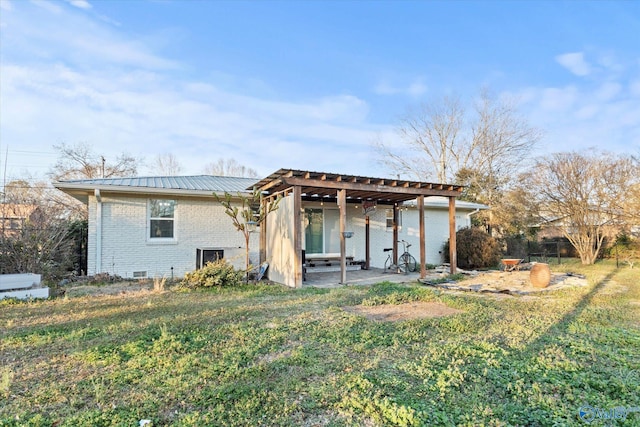 back of house with brick siding and metal roof