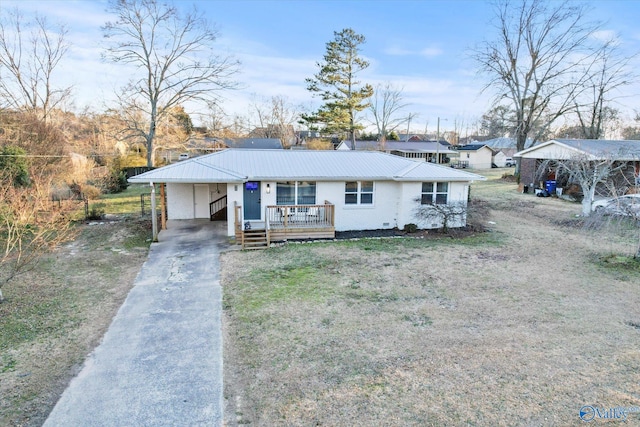 view of front facade featuring brick siding, a porch, metal roof, a carport, and driveway