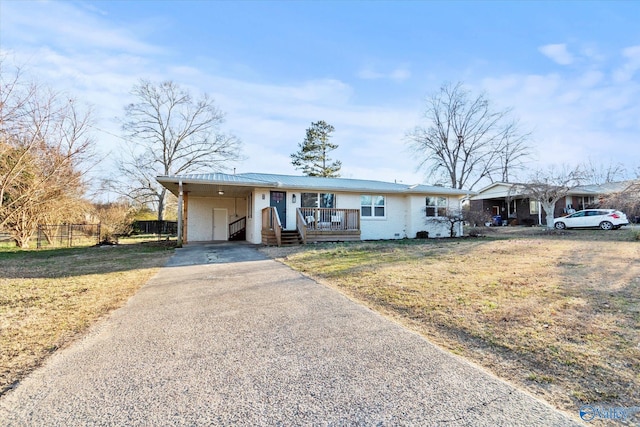 ranch-style home with a front lawn, aphalt driveway, and a carport