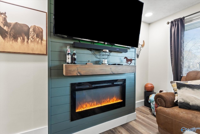 living area featuring recessed lighting, a large fireplace, baseboards, and wood finished floors