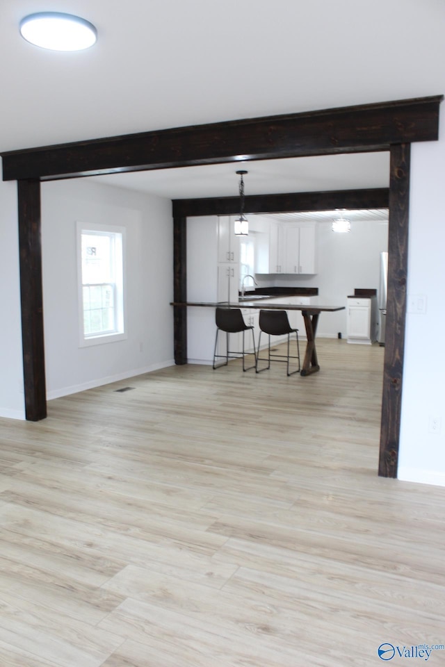 dining space with sink and beam ceiling