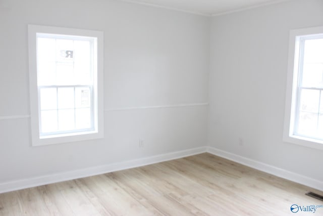 empty room featuring crown molding and light hardwood / wood-style floors