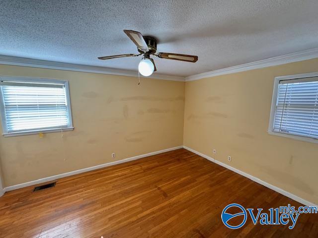 spare room featuring ceiling fan, crown molding, a textured ceiling, and hardwood / wood-style flooring