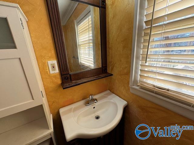 bathroom featuring crown molding and sink