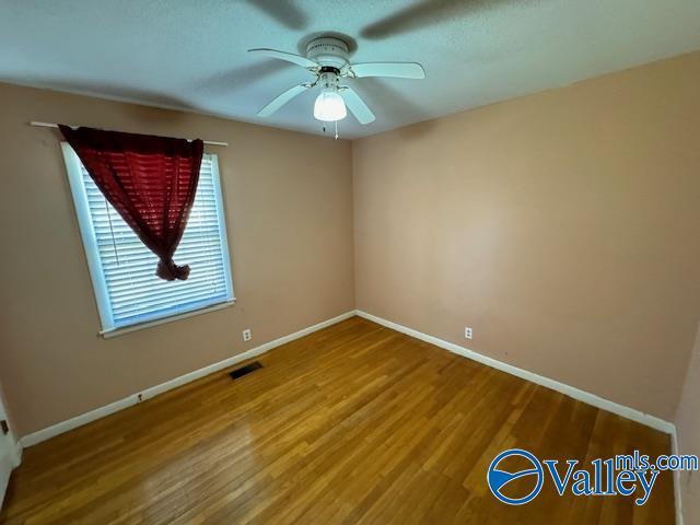 unfurnished room featuring wood-type flooring and ceiling fan