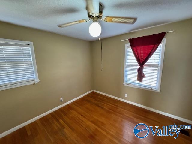 unfurnished room featuring hardwood / wood-style floors and ceiling fan