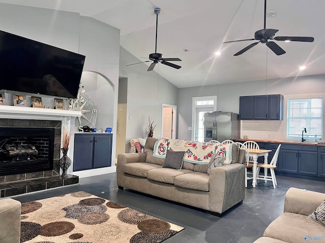 living room featuring a fireplace, sink, ceiling fan, and high vaulted ceiling