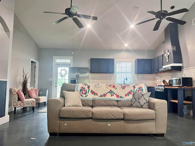 living room with high vaulted ceiling, ceiling fan, and a healthy amount of sunlight