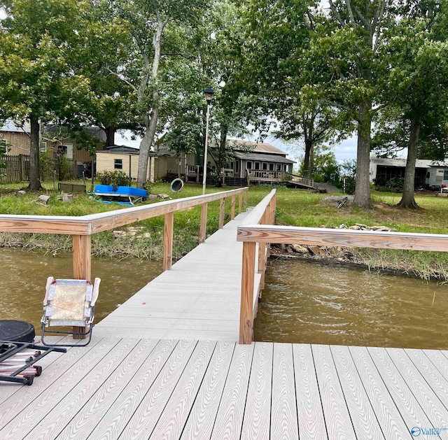 view of dock featuring a yard and a water view