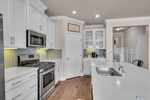 kitchen with stainless steel appliances, wood-type flooring, sink, and white cabinets