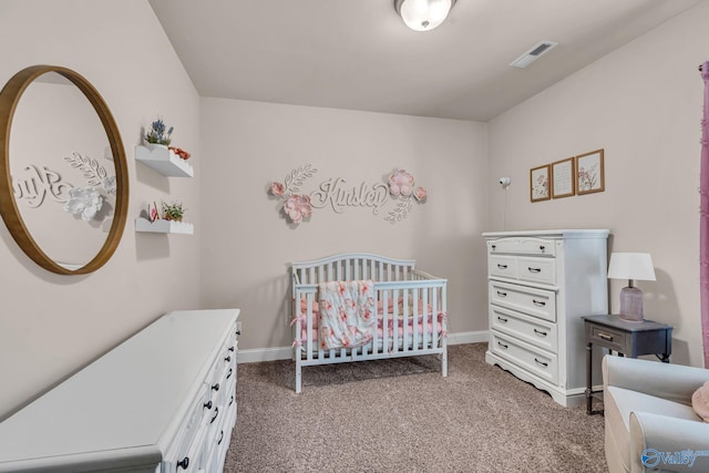 carpeted bedroom featuring a nursery area