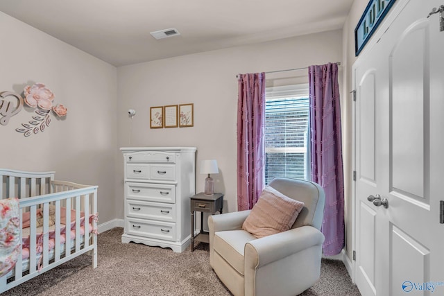 bedroom featuring a crib and carpet flooring