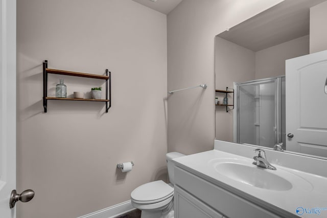 bathroom with a shower with door, vanity, and toilet