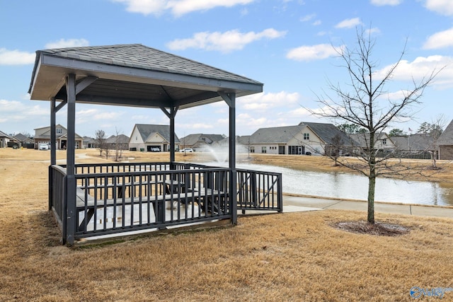 dock area with a gazebo, a lawn, and a water view