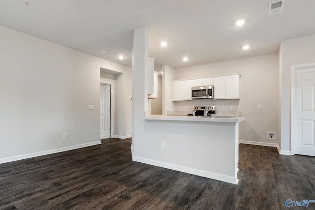 4025 Sherri St SW, Decatur, AL 35603 - kitchen featuring stainless steel microwave, dark wood finished floors, light countertops, white cabinetry, and recessed lighting