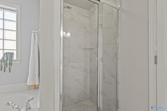 bathroom featuring plenty of natural light and shower with separate bathtub