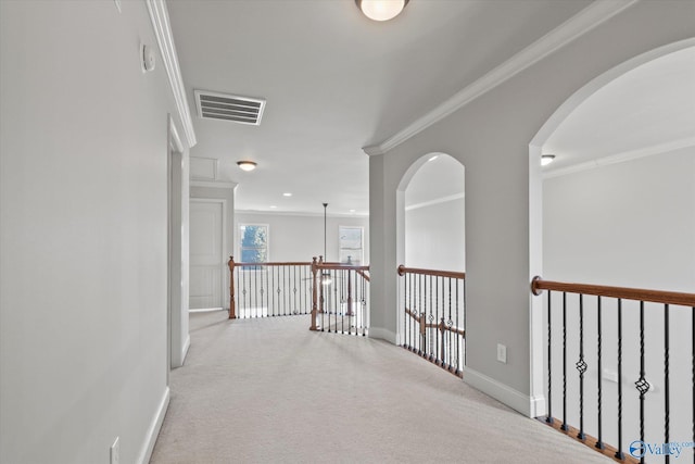 hallway with crown molding and light colored carpet