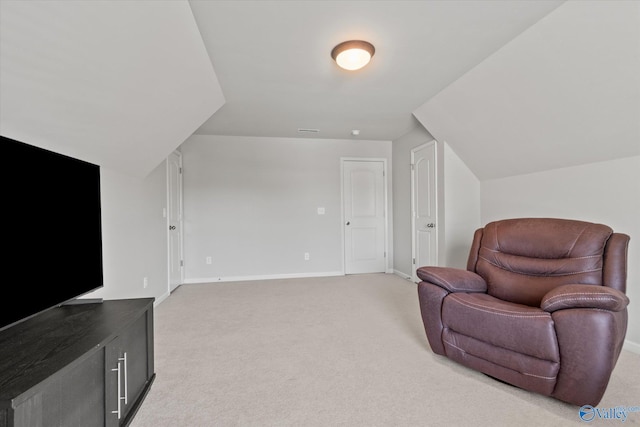 living area featuring vaulted ceiling and carpet