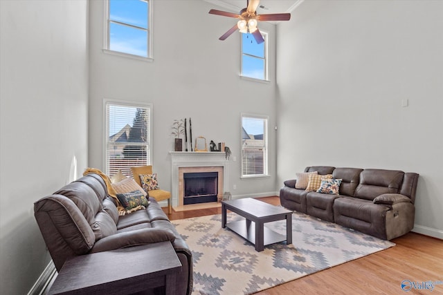 living room featuring a towering ceiling, hardwood / wood-style floors, and ceiling fan