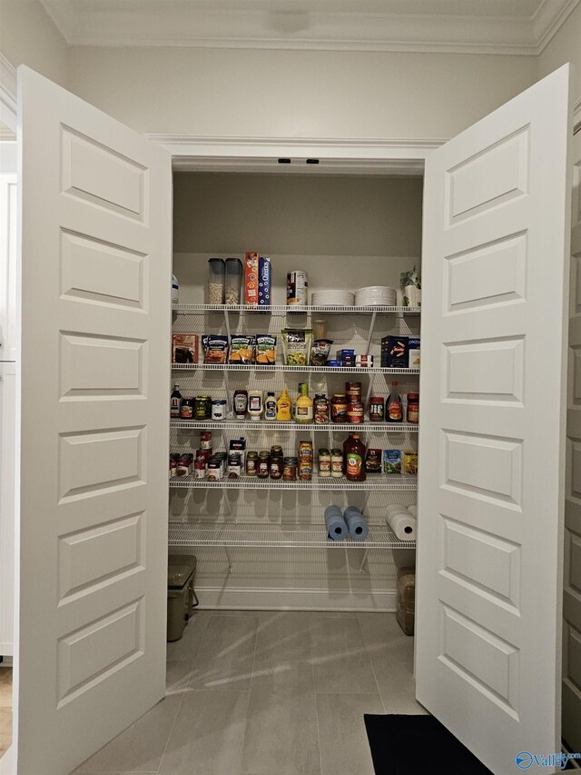 washroom with light tile patterned floors, crown molding, cabinets, and washing machine and dryer