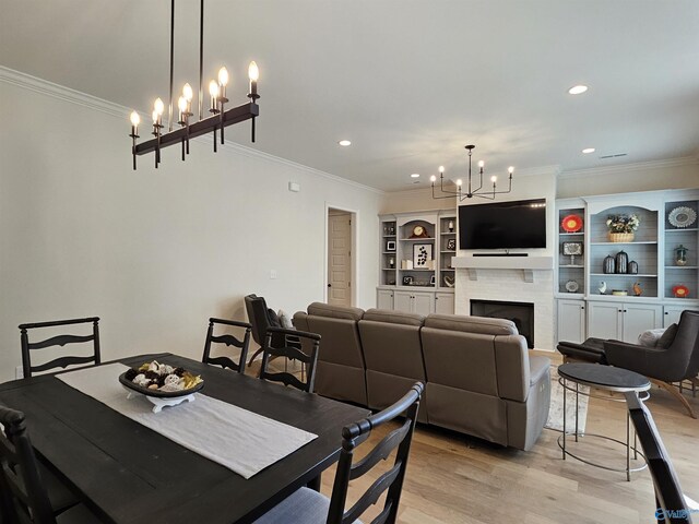 bedroom with light wood-type flooring, crown molding, a chandelier, a closet, and a walk in closet