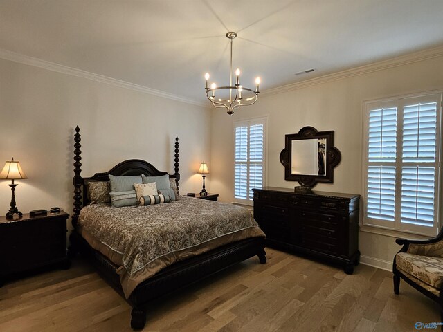 bedroom featuring hardwood / wood-style flooring, a chandelier, and ornamental molding