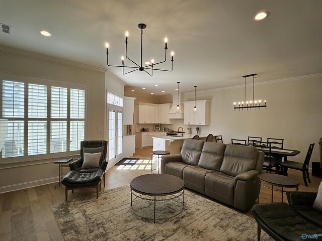 kitchen with custom exhaust hood, stainless steel gas stove, white cabinetry, and light hardwood / wood-style flooring