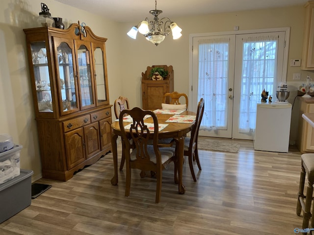 dining area featuring a notable chandelier, light hardwood / wood-style flooring, and french doors