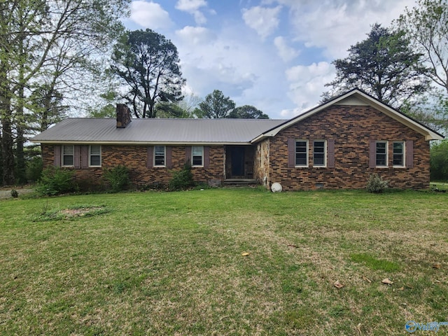 ranch-style home with a chimney, metal roof, and a front yard