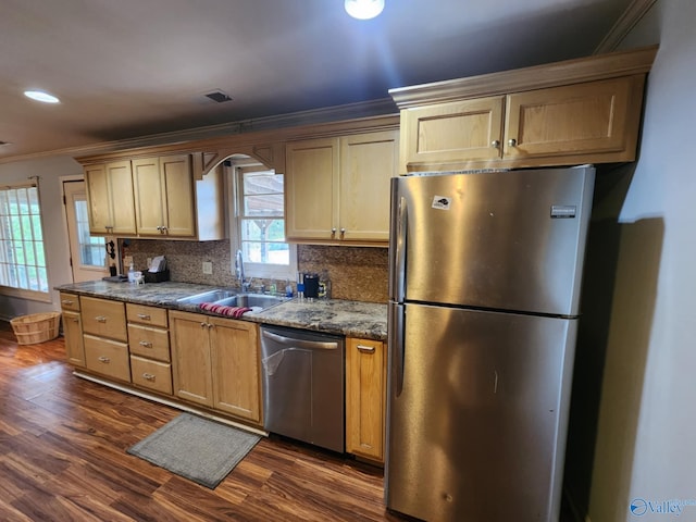 kitchen with crown molding, stainless steel appliances, a sink, and backsplash