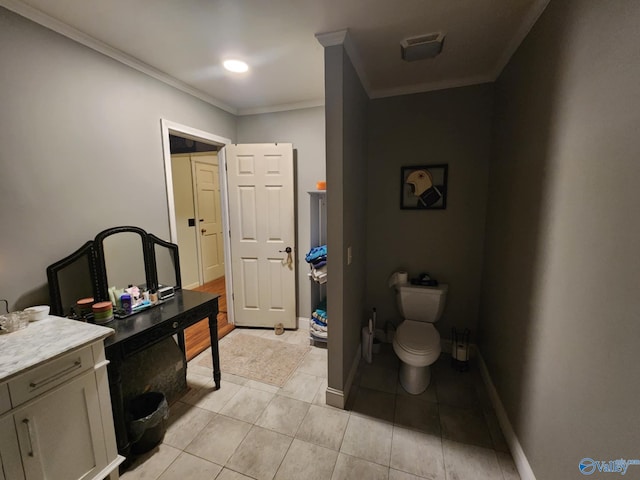 bathroom with toilet, tile patterned floors, ornamental molding, and baseboards