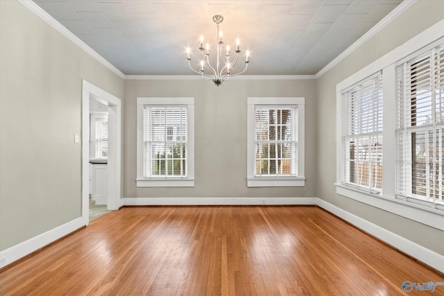 unfurnished dining area featuring a chandelier, ornamental molding, a healthy amount of sunlight, and wood-type flooring