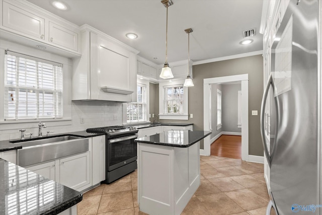 kitchen with pendant lighting, a healthy amount of sunlight, white cabinetry, and appliances with stainless steel finishes